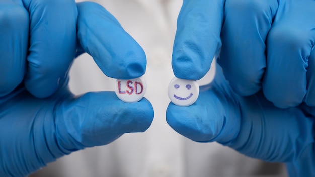 Blue and red LSD pills in doctor hands psychedelic drug for the treatment of severe stages of depression