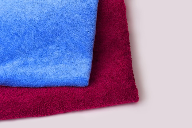 Photo blue and red towel on a white background folded fresh towels close up terrycolored fabric