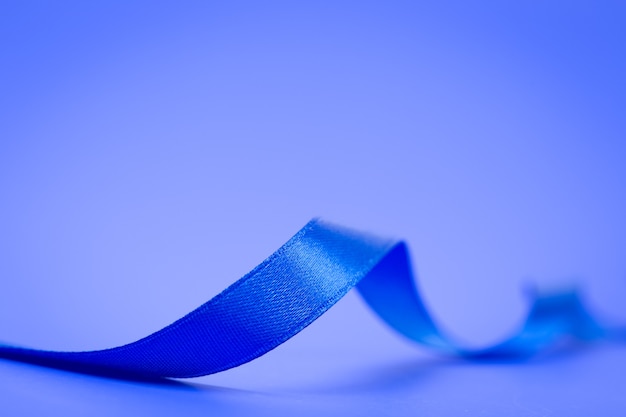Blue ribbon on blue surface
