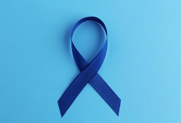 Blue ribbon on color background Colon cancer concept