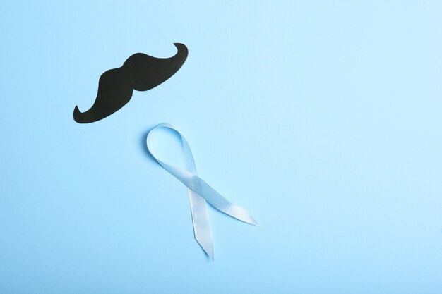 Blue ribbon on a colored background top view mens cancer mens health