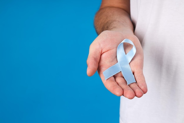 Photo blue ribbon in a man's hand movember concept