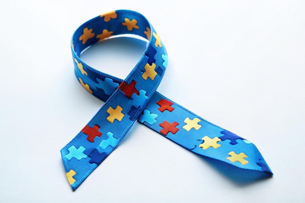 a blue ribbon with puzzle pieces on it is tied to a blue ribbon