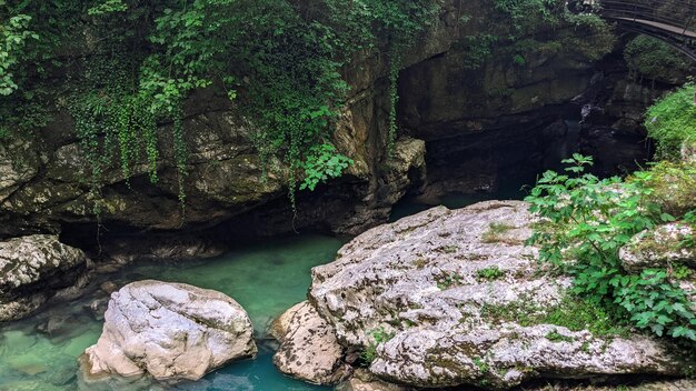 Blue river flows among the stones in the forest