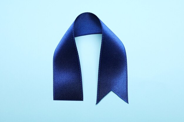 Blue satin ribbon on blue background, close up