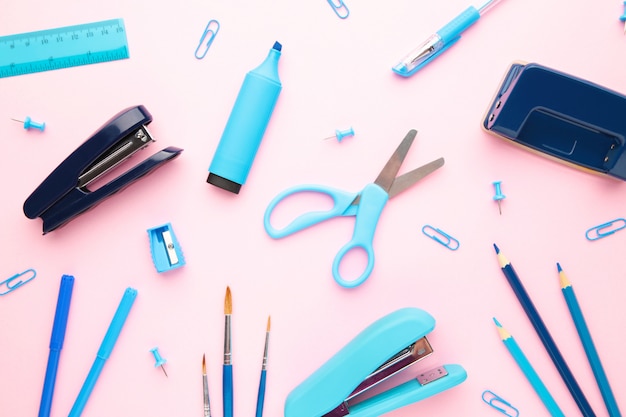 Photo blue school supplies on pink background. back to school. flat lay.