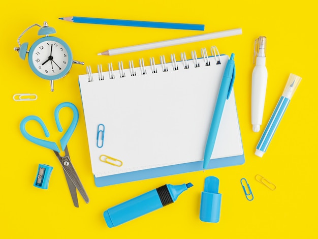 Blue school supplies on yellow background with empty notebook blank. overhead