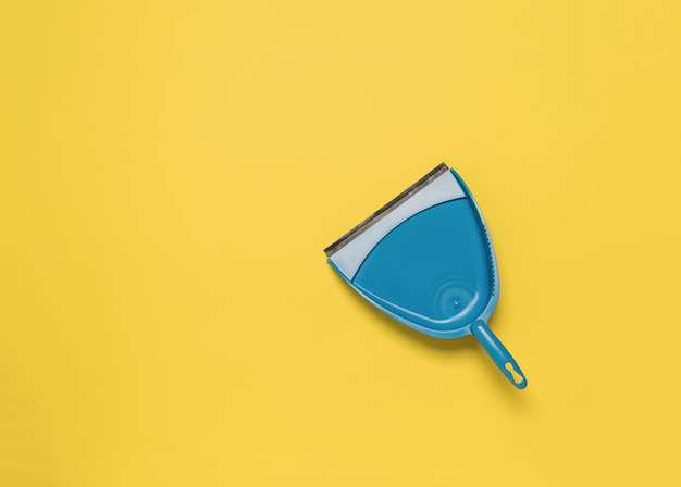 A blue scoop on a bright yellow background Flat lay