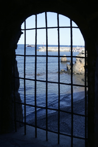 Blue sea behind the jail, arch window