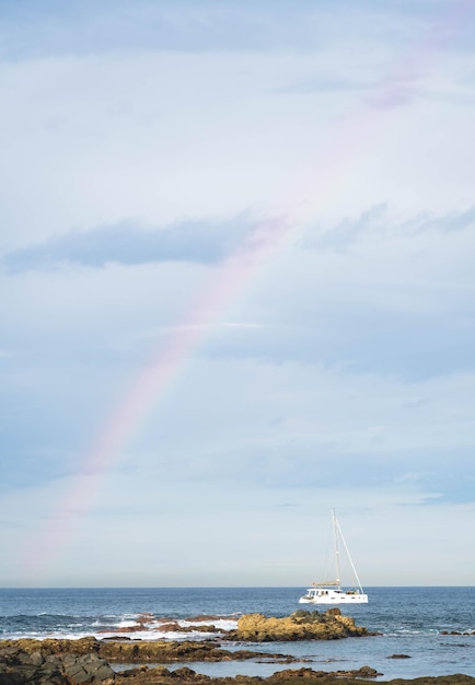 Blue sea and sailboat Rainbow in the sky