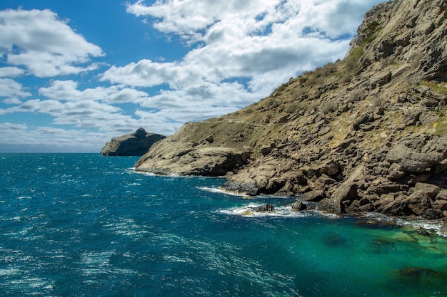 The blue sea washes the rocks