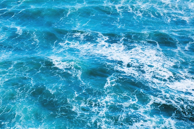 Foto acqua di mare blu con onde e schiuma bianca