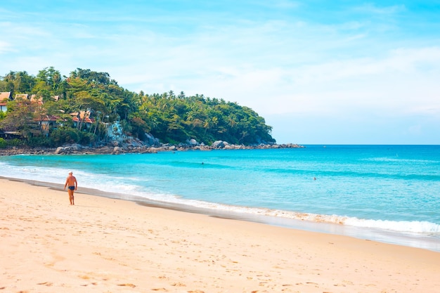 Foto mare blu con spiaggia sabbiosa e turisti sull'isola tropicale viaggi e turismo riposo e relax