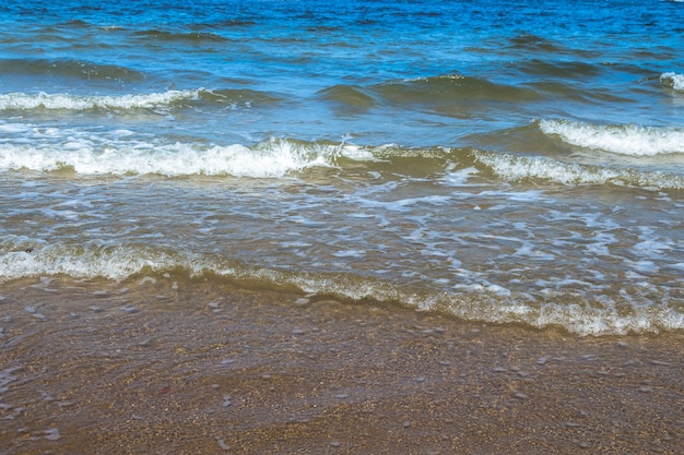 Blue sea with waves and sand beach