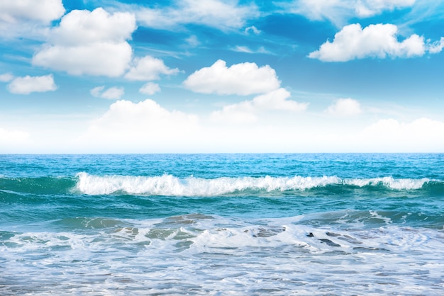 Blue sea with waves and white clouds