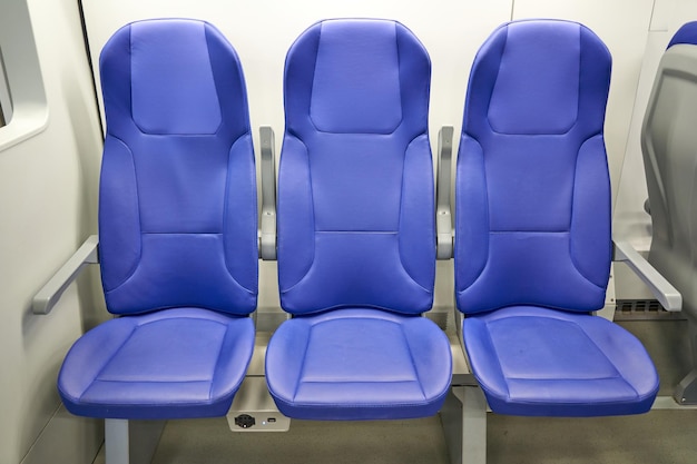 Blue seats in a bus that says'electric'on the side