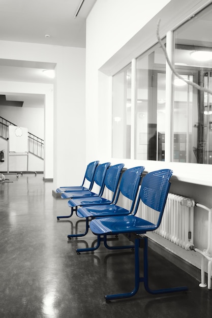 Photo blue seats in an empty hallway of a school