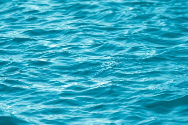 Blue seawater waves with sunlight reflection top view