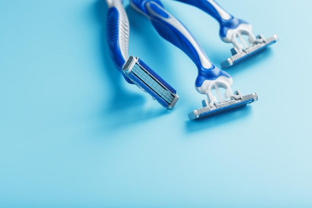 Blue shaving machines in a row on a blue background with ice cubes