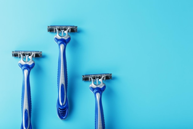 Blue shaving machines in a row on a blue background with ice cubes