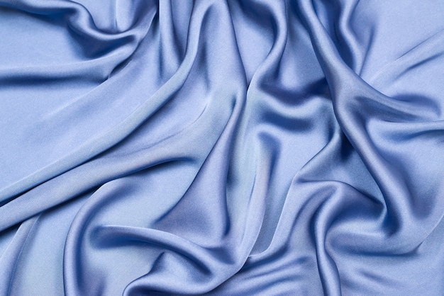 Blue silk or satin luxury fabric texture. Top view.