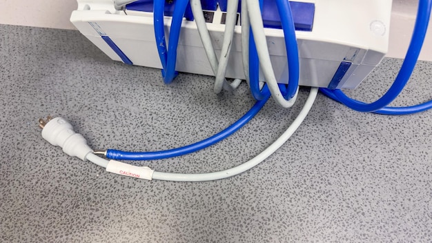 A blue and silver cable is laying on a gray floor.