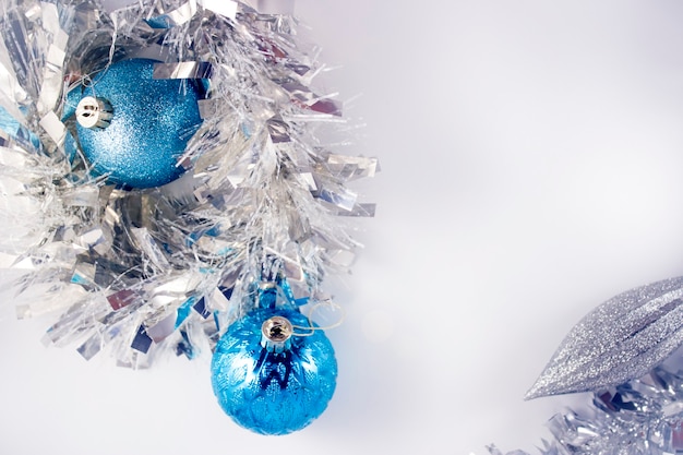 Blue and silver xmas ornaments on bright holiday background with space for text. Merry christmas!