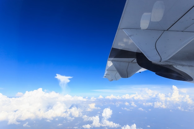 写真 青い空と飛行機の翼を窓の内側から