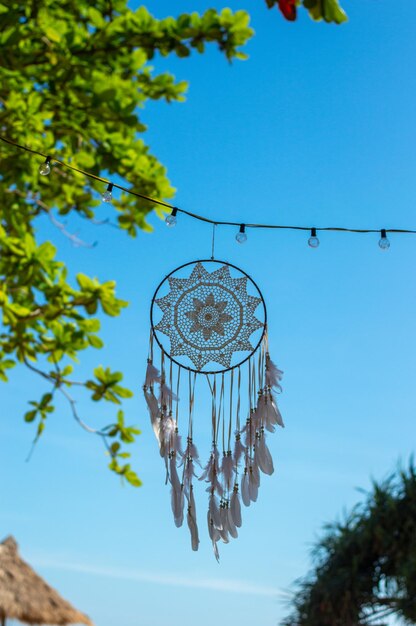 On a blue sky background there is a dreamcatcher