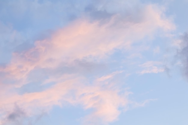 日没時の淡いピンクの雲と青空の背景