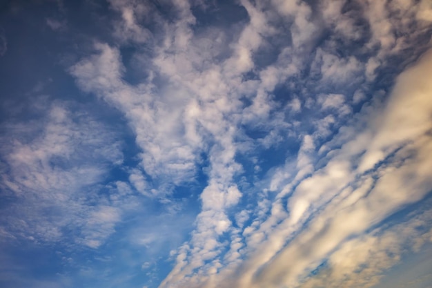 Blue sky background with tiny stratus cirrus striped clouds\
clearing day and good windy weather