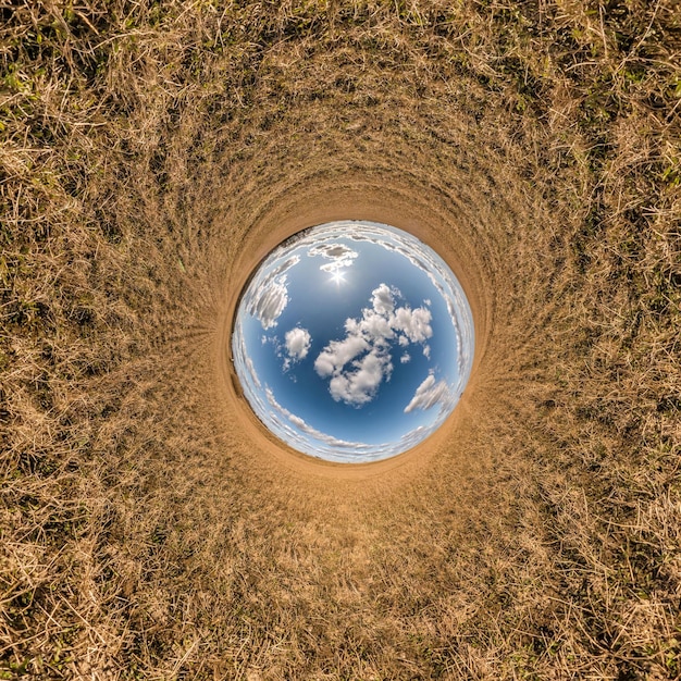 Blue sky ball in middle of swirling field inversion of tiny
planet transformation of spherical panorama 360 degrees curvature
of space