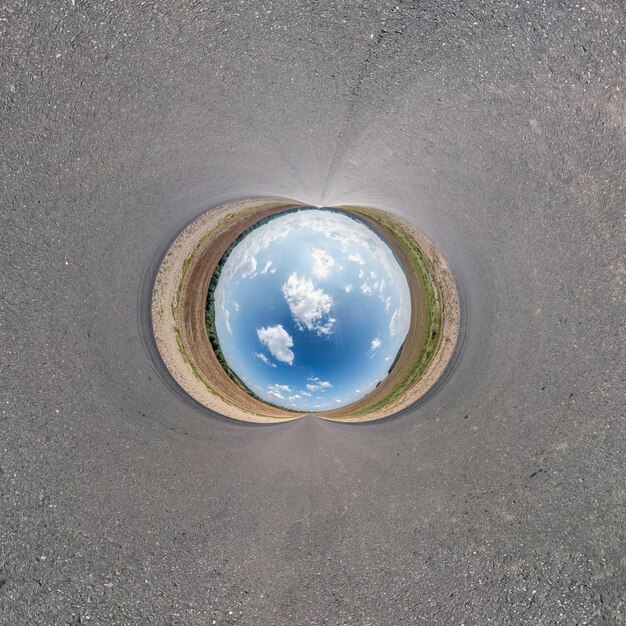 Шар голубого неба посреди закрученной дороги Инверсия крошечной планеты Трансформация сферической панорамы 360 градусов Кривизна пространства