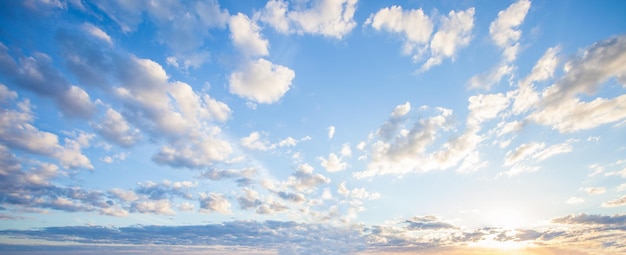 Blue sky clouds background Beautiful landscape with clouds and orange sun on sky