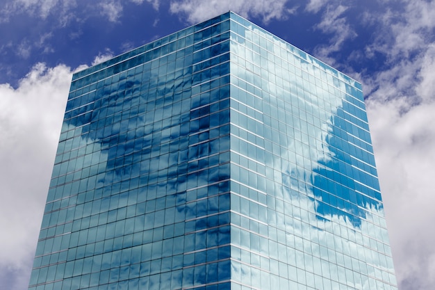 Blue sky and clouds reflecting in windows of modern office building