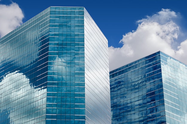 Foto cielo blu e nuvole che riflettono in finestre dell'edificio per uffici moderno