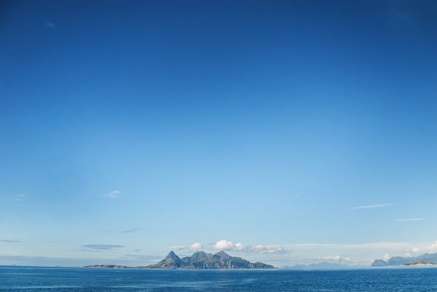 Blue sky and an island in the distance. Helligvaer is an island group in the Vestfjorden in the municipality of Bodo, in Nordland county, Norway