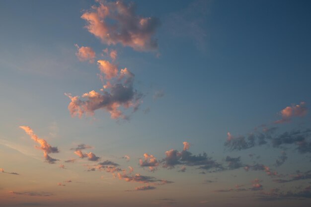 Blue sky at sunrise with pink clouds Clouds illuminated by the morning sun on the seashore