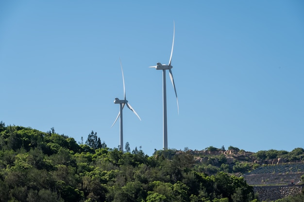 Under the blue sky, there was a windmill on the mountain