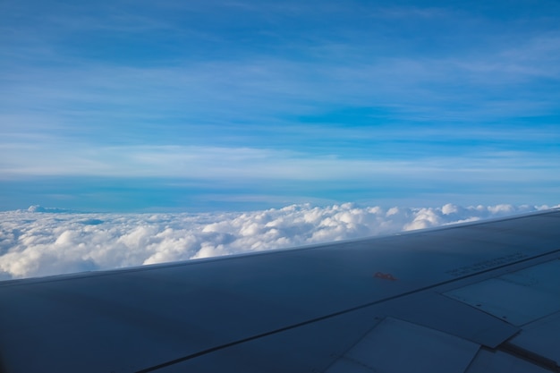 飛行機の窓から雲の眺めを持つ青空