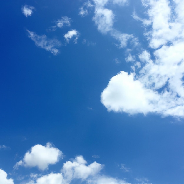 A blue sky with clouds and a heart shaped cloud