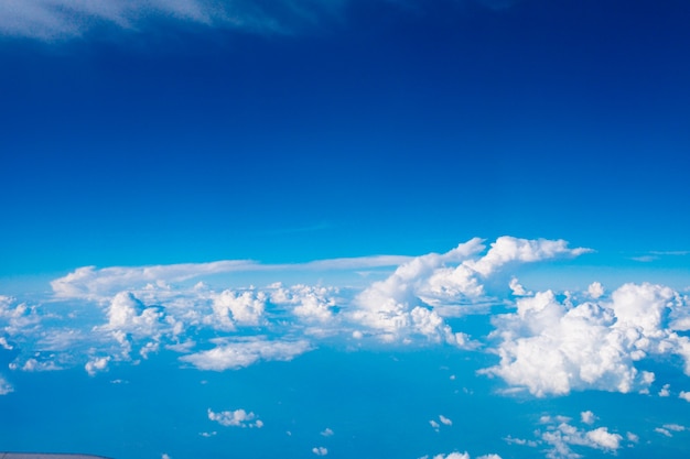 Blue sky with clouds and sun on airplane view.