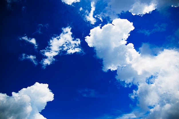 Blue sky with the fluffy white clouds natural background