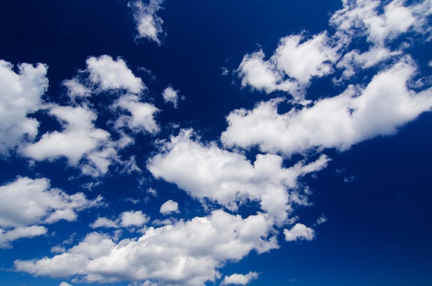 Blue sky with the fluffy white clouds natural background