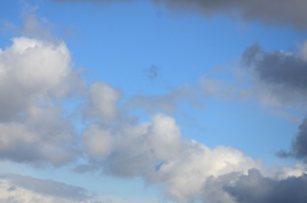 A blue sky with lots of white clouds of different sizes