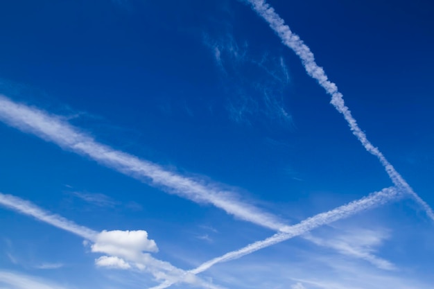 写真 飛行機で作られた白い雲のラインがたくさんある青い空