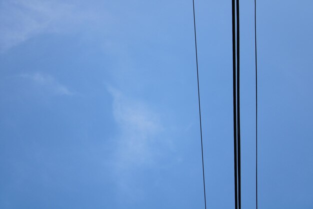 Photo a blue sky with some wires and a white cloud
