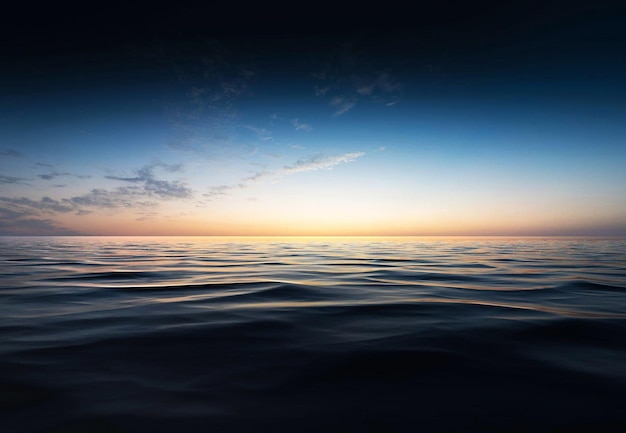 A blue sky with a sunset over the ocean