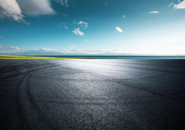 A blue sky with a tire tracks on the road.