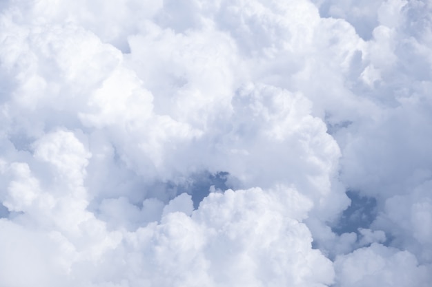 Blue sky with white clouds in sunny weather. Fluffy sky cloudy view atmosphere  from airplane window.